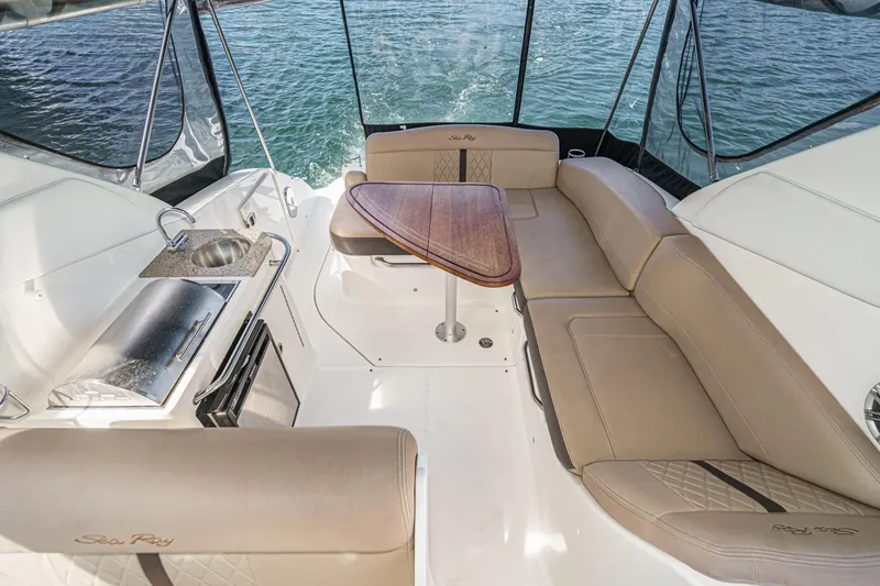 Slide: The Image of 2016 Sea Ray 280 Sundancer interior with seating, table, and kitchenette on the water. - 13