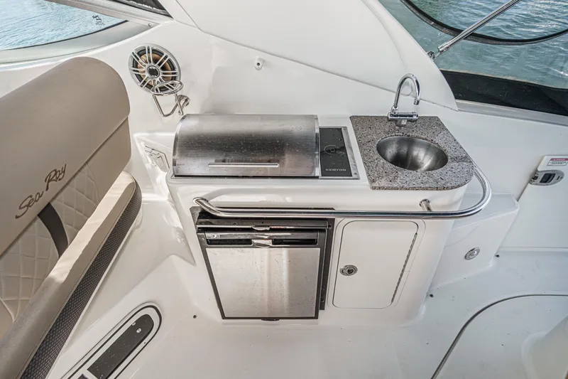 Slide: The Image of 2016 Sea Ray 280 Sundancer boat kitchenette with sink, grill, and storage. - 15