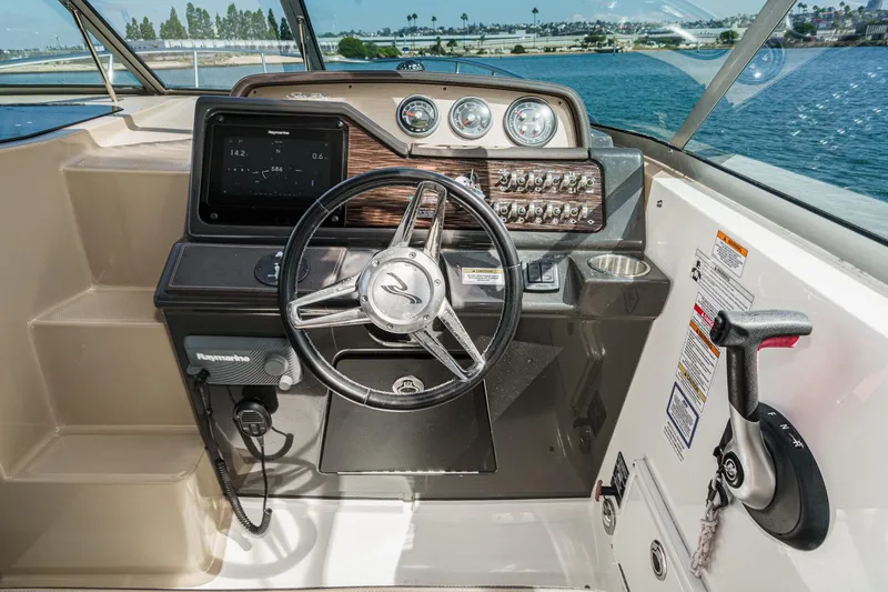 Slide: The Image of Helm of 2016 Sea Ray 280 Sundancer with steering wheel and control panel. - 18