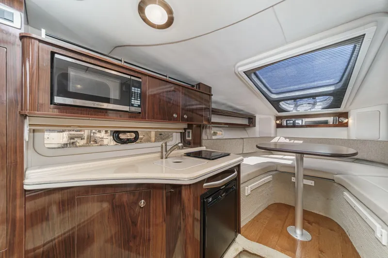 Slide: The Image of 2016 Sea Ray 280 Sundancer cabin with kitchenette and dining area. - 22