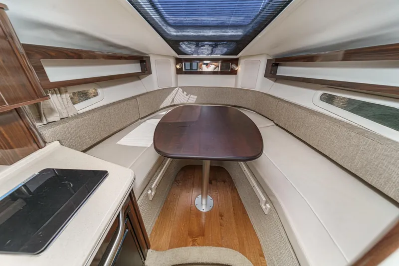Slide: The Image of 2016 Sea Ray 280 Sundancer cabin interior with dining table and seating area. - 23