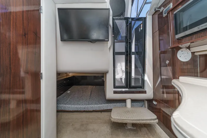 Slide: The Image of 2016 Sea Ray 280 Sundancer cabin interior with bed, TV, and window. - 27