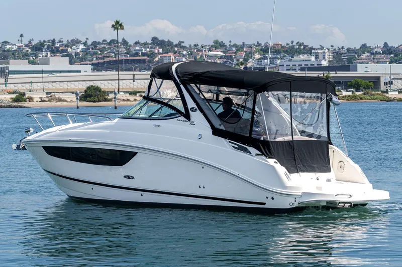 Slide: The Image of 2016 Sea Ray 280 Sundancer boat cruising on calm waters near a coastal city. - 3