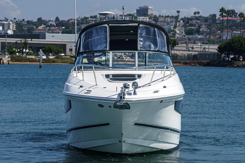 Slide: The Image of 2016 Sea Ray 280 Sundancer yacht on calm water, urban backdrop. - 8