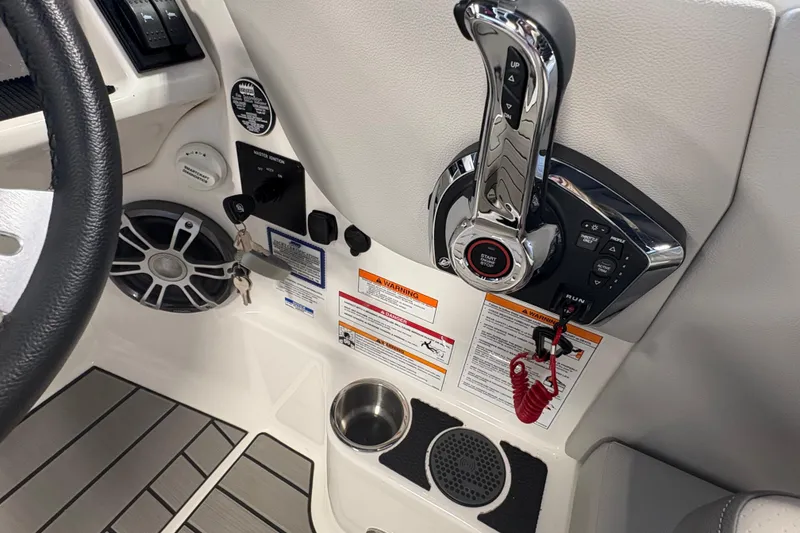 Slide: The Image of 2025 Sea Ray SDX 270 Surf boat control panel with throttle and warning labels. - 12