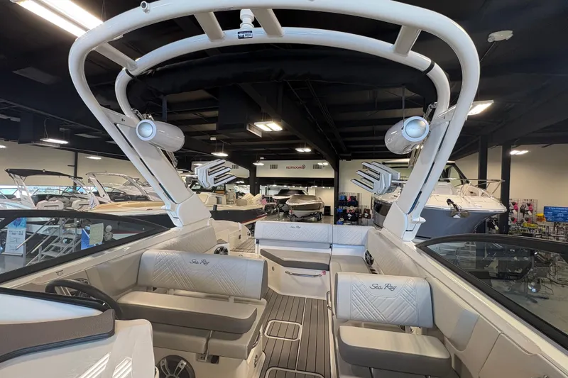 Slide: The Image of 2025 Sea Ray SDX 270 Surf boat interior with seating and speakers in showroom. - 15