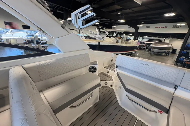 Slide: The Image of 2025 Sea Ray SDX 270 Surf boat interior in showroom, featuring luxurious seating and modern design. - 16