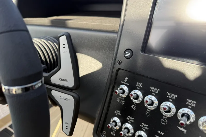 Slide: The Image of 2026 Moomba Mojo boat dashboard with cruise control and light switches. - 26