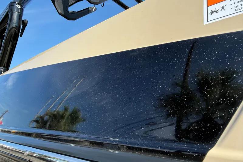 Slide: The Image of 2026 Moomba Mojo boat with sleek black and beige exterior under clear blue sky. - 39