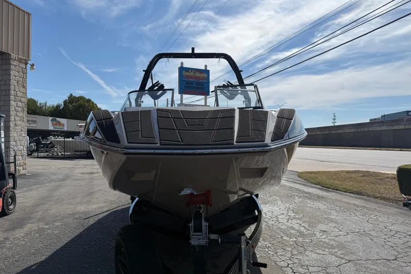 Slide: The Image of 2026 Moomba Mojo boat on trailer, parked outdoors under a clear sky. - 5