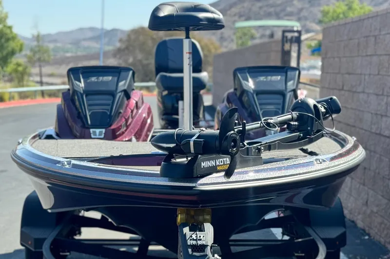 Slide: The Image of 2023 Nitro Z18 boat with Minn Kota Maxxum trolling motor, parked outdoors. - 2
