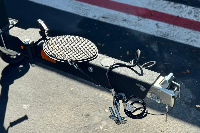 Slide: The Image of Trailer hitch of a 2023 Nitro Z18 on asphalt, featuring safety cables and locking mechanism. - 20