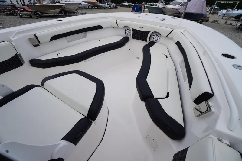 Slide: The Image of 2021 Tidewater 256 CC Adventure boat interior with cushioned seating and speakers. - 18