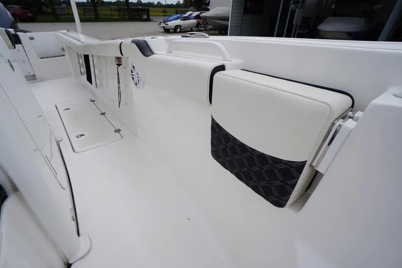 Slide: The Image of 2021 Tidewater 256 CC Adventure boat interior with white seating and storage compartments. - 21
