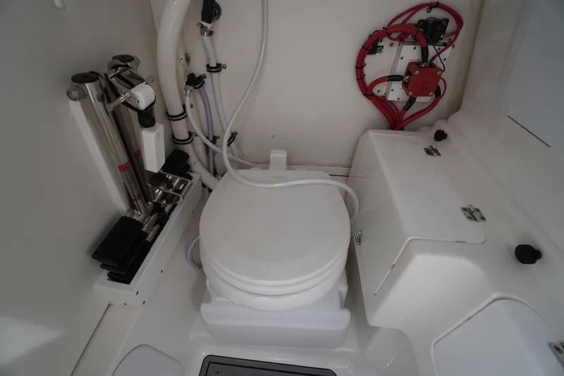 Slide: The Image of 2021 Tidewater 256 CC Adventure boat interior with marine toilet and storage compartments. - 28