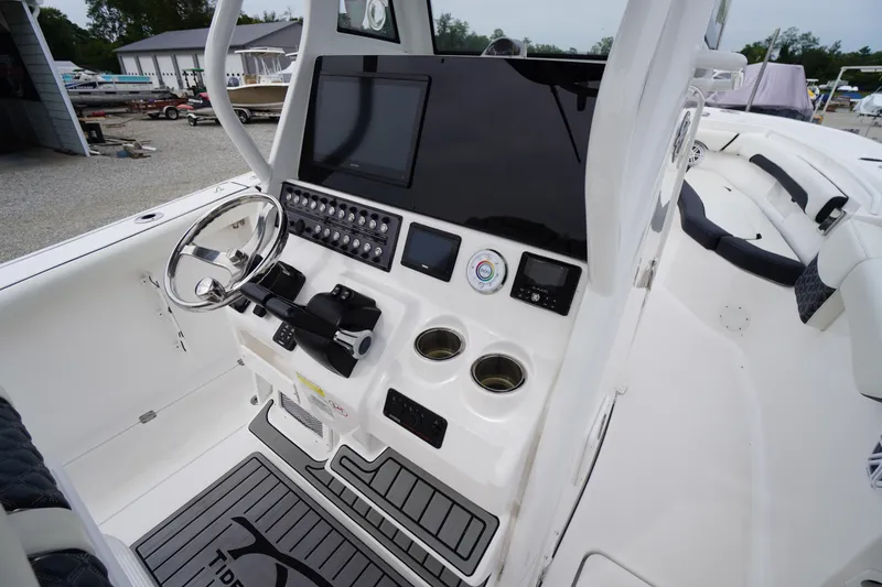 Slide: The Image of 2021 Tidewater 256 CC Adventure boat cockpit with steering wheel and control panel. - 29