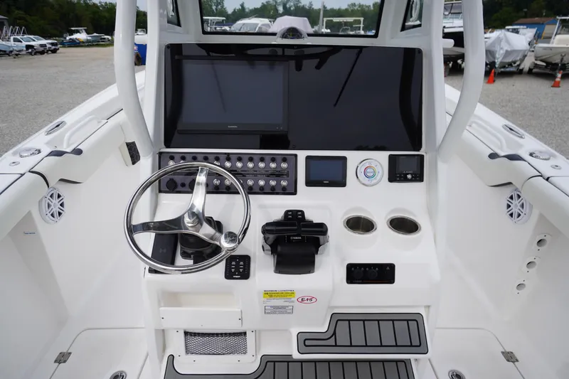 Slide: The Image of 2021 Tidewater 256 CC Adventure boat console with steering wheel and electronic controls. - 30