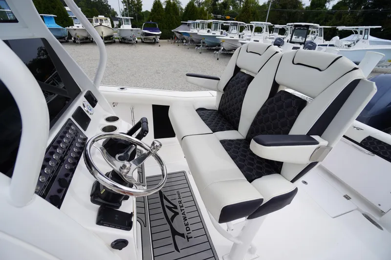 Slide: The Image of 2021 Tidewater 256 CC Adventure boat interior with dual seats and steering console. - 33