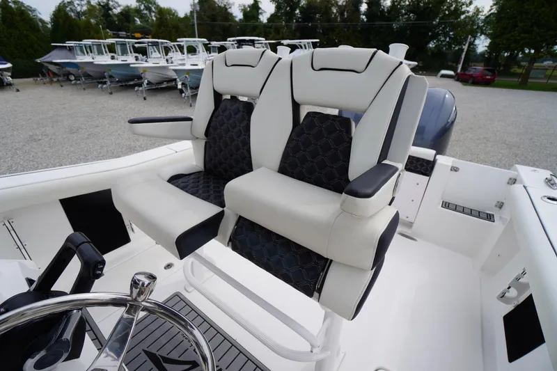 Slide: The Image of 2021 Tidewater 256 CC Adventure boat with dual cushioned seats and steering wheel. - 35
