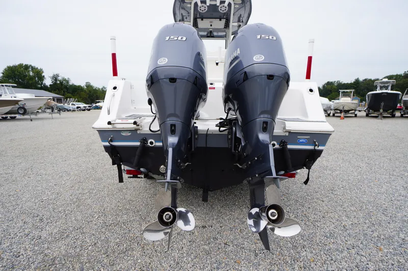 Slide: The Image of 2021 Tidewater 256 CC Adventure boat with dual Yamaha 150 engines, displayed on gravel lot. - 55