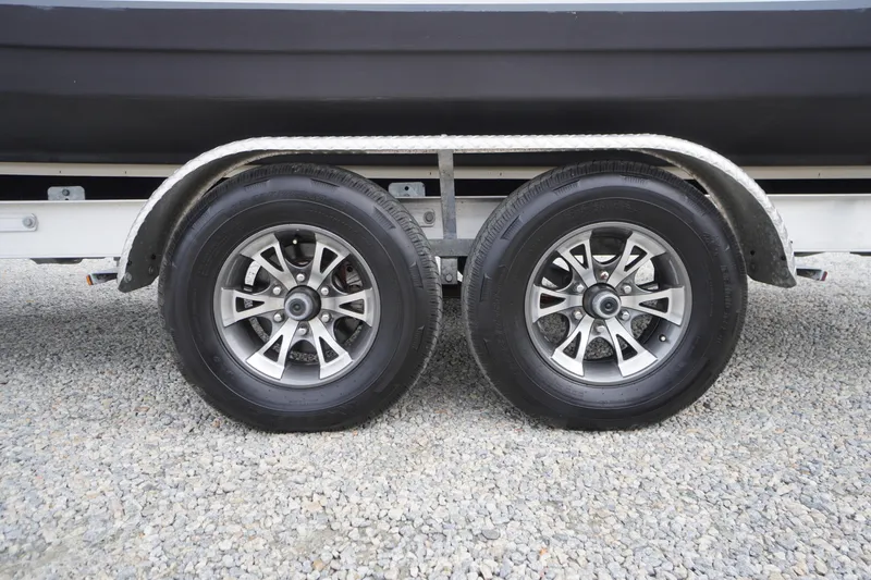 Slide: The Image of Trailer wheels of a 2021 Tidewater 256 CC Adventure boat on gravel surface. - 67