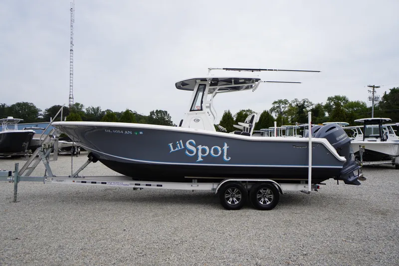 Slide: The Image of 2021 Tidewater 256 CC Adventure boat on trailer, side view, gray hull, named "Lil Spot". - 68