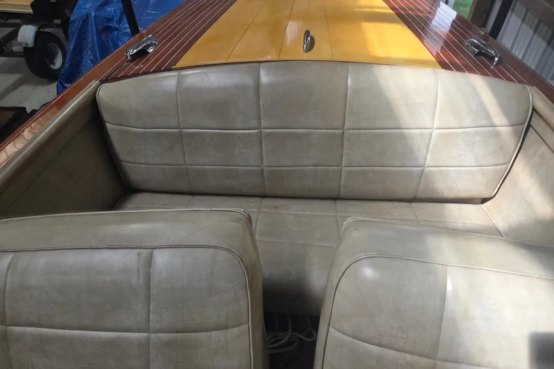Slide: The Image of 1960 Chris Craft 19 Capri boat interior with beige leather seats and wooden deck. - 11