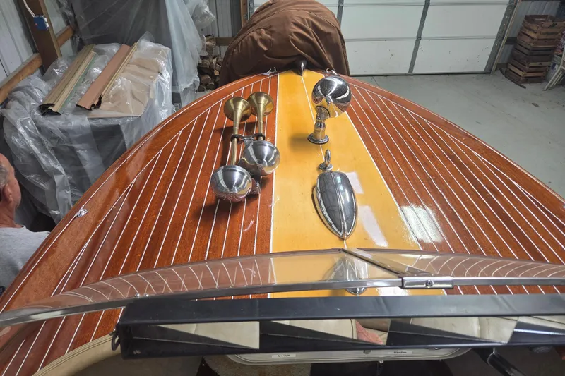 Slide: The Image of 1960 Custom Chris Craft 19 Capri boat with polished wood deck and chrome details in a garage. - 14