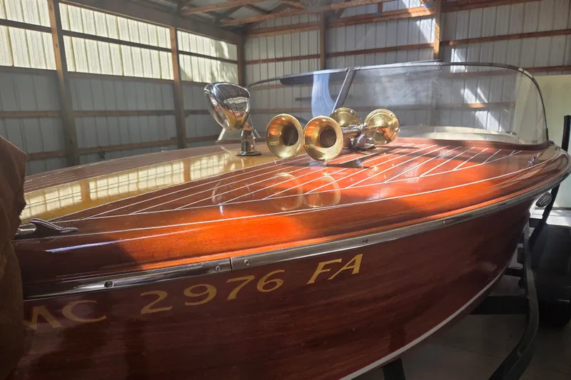 Slide: The Image of 1960 Custom Chris Craft 19 Capri boat with polished wood finish in a sunlit garage. - 2