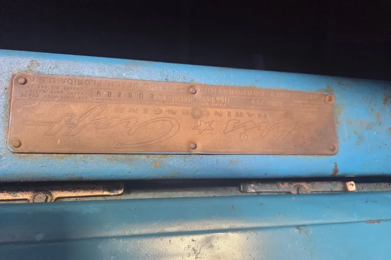 Slide: The Image of 1960 Chris Craft 19 Capri engine plate on blue surface, showcasing vintage marine engineering. - 21