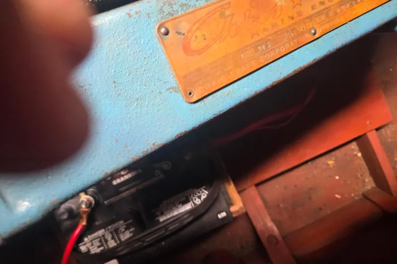 Slide: The Image of Close-up of a 1960 Chris Craft 19 Capri engine compartment with visible battery and label. - 23