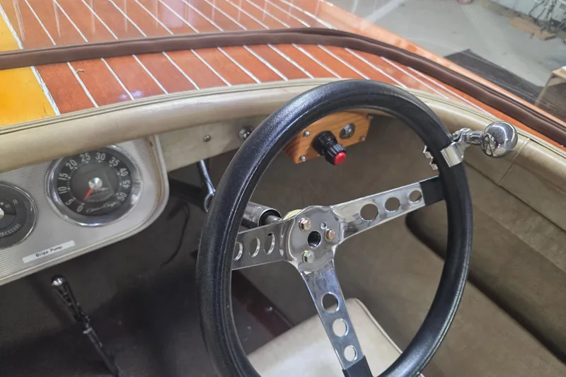 Slide: The Image of 1960 Chris Craft 19 Capri dashboard with vintage steering wheel and wooden paneling. - 9