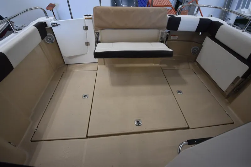 Slide: The Image of 2018 Ranger Tugs R-23 boat interior with beige seating and storage compartments. - 10