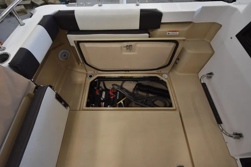 Slide: The Image of 2018 Ranger Tugs R-23 boat interior with open storage compartment and visible wiring. - 11