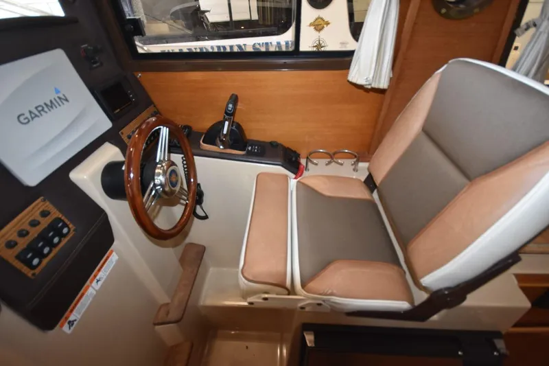 Slide: The Image of 2018 Ranger Tugs R-23 helm with Garmin system, steering wheel, and comfortable seating. - 22