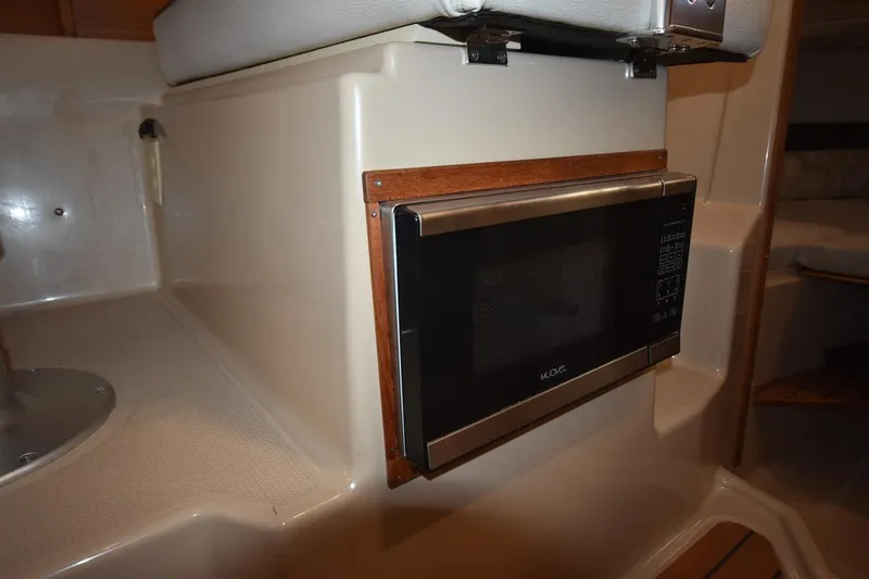 Slide: The Image of 2018 Ranger Tugs R-23 interior with built-in microwave and seating area. - 30