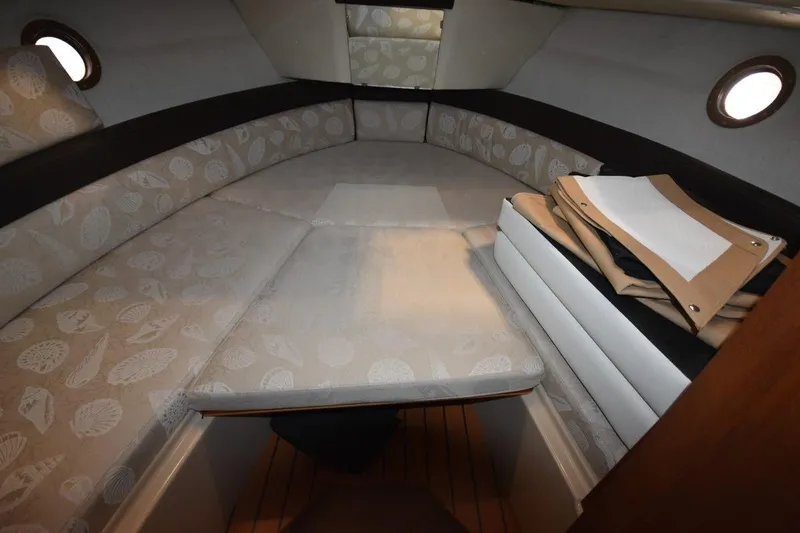 Slide: The Image of 2018 Ranger Tugs R-23 cabin interior with patterned cushions and portholes. - 33