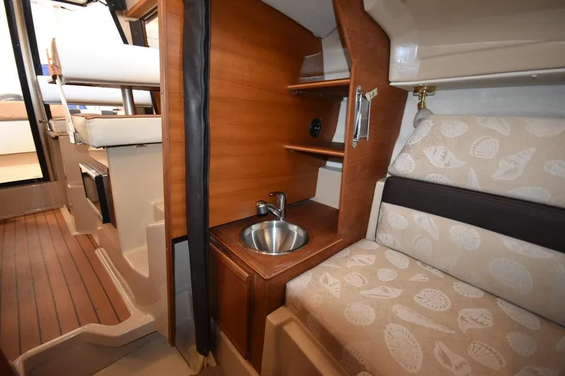 Slide: The Image of 2018 Ranger Tugs R-23 interior with wood finish, compact sink, and patterned seating. - 34