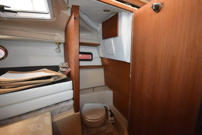 Slide: The Image of 2018 Ranger Tugs R-23 interior cabin with compact toilet and wooden accents. - 35