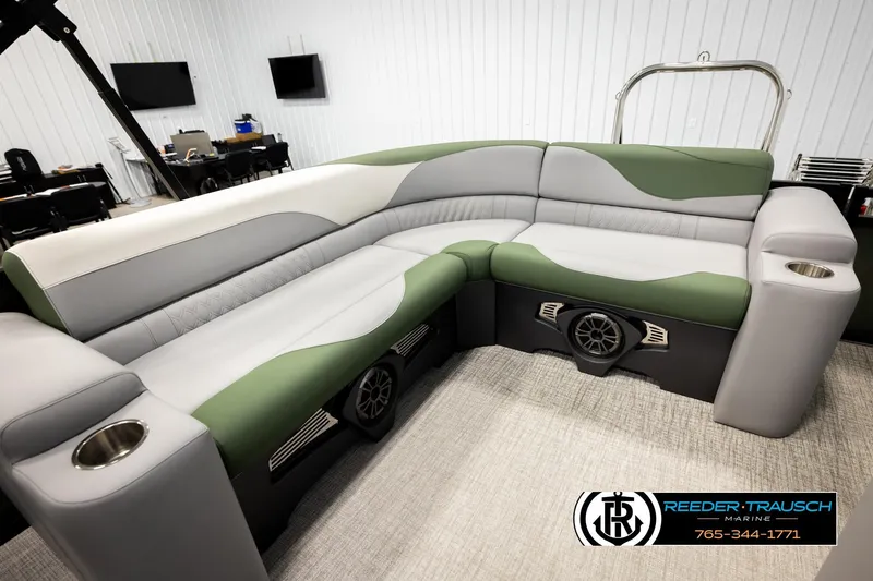 Slide: The Image of Luxurious 2026 Avalon LSZ EL boat seating with green and gray upholstery in a showroom. - 21