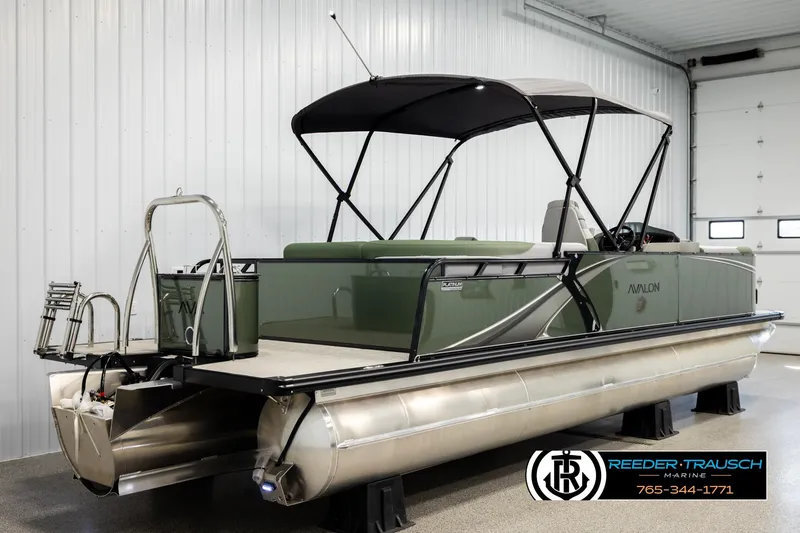 Slide: The Image of 2026 Avalon LSZ EL pontoon boat in showroom, featuring sleek design and canopy. - 6