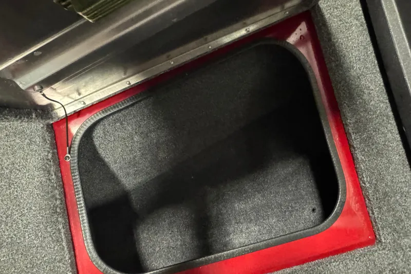 Slide: The Image of Storage compartment in 2023 Tracker Pro Guide V-175 WT boat, featuring red trim and carpeted interior. - 17