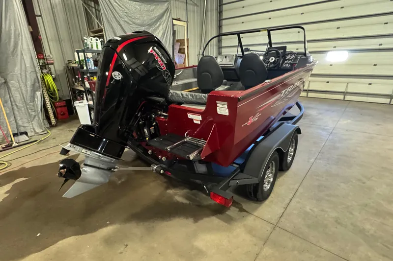 Slide: The Image of 2023 Tracker Pro Guide V-175 WT boat in garage, featuring powerful Mercury outboard motor. - 3