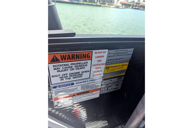 Slide: The Image of Warning labels on 2023 Bennington R 27 RSRAX2 boat, emphasizing safety and capacity limits. - 11