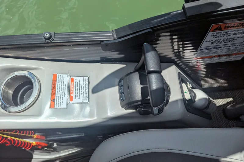 Slide: The Image of Control panel of 2023 Bennington R 27 RSRAX2 boat with warning labels and cup holder. - 14