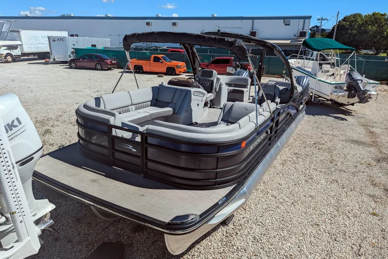 Slide: The Image of 2023 Bennington R 27 RSRAX2 pontoon boat with spacious seating, parked outdoors. - 3
