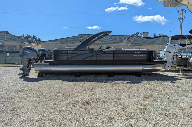 Slide: The Image of 2023 Bennington R 27 RSRAX2 pontoon boat with Yamaha engines, parked outdoors. - 5