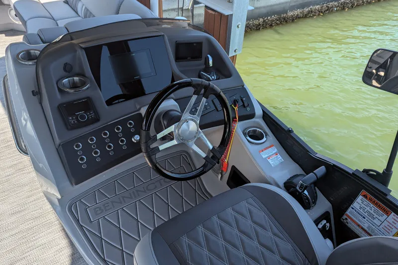 Slide: The Image of 2023 Bennington R 27 RSRAX2 boat dashboard with steering wheel and control panel. - 7