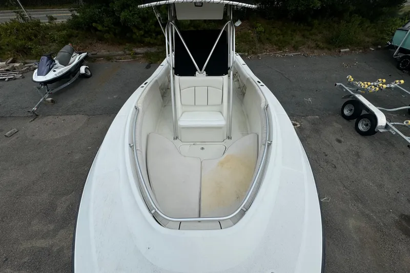 Slide: The Image of 2004 Hydra-Sports Vector 2400 CC boat, white interior, parked on pavement near a jet ski. - 5