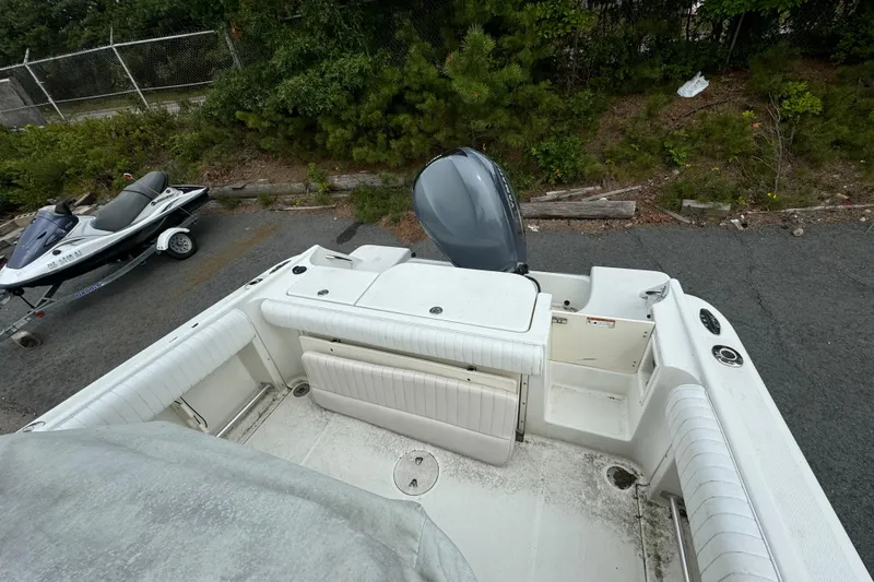 Slide: The Image of 2004 Hydra-Sports Vector 2400 CC boat with outboard motor, parked near a jet ski. - 6